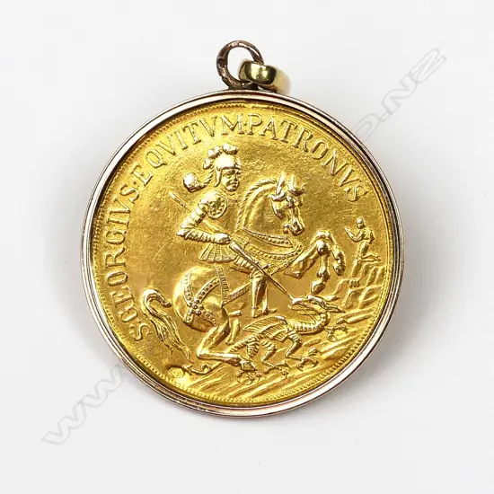 A vintage gold St George and The Dragon good luck pendant charm