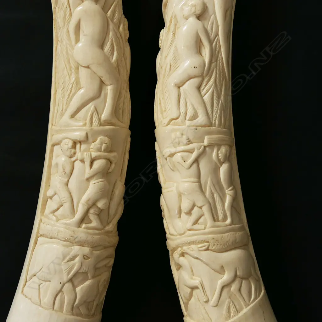 A pair of old African carved ivory tusks carved with a naked woman Image 1++