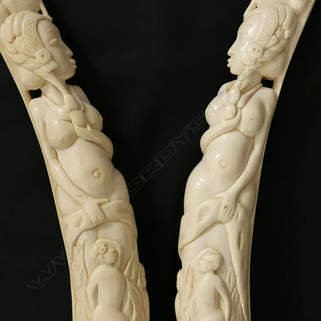 A pair of old African carved ivory tusks carved with a naked woman Image 1++