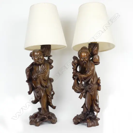 A pair of Chinese carved wood figural based table lamps