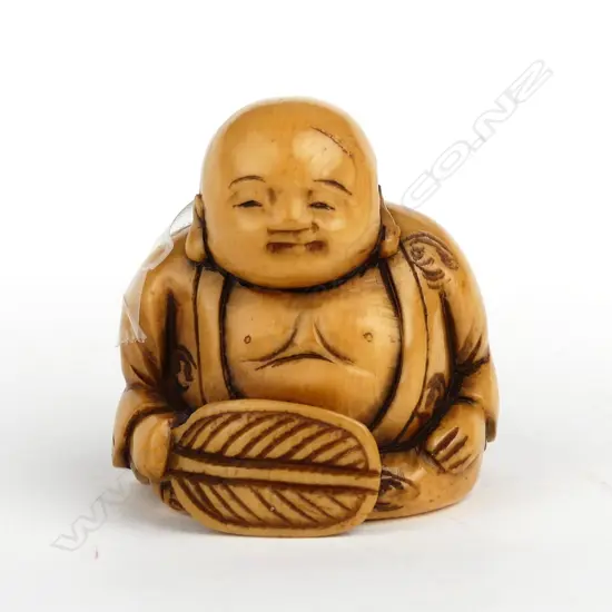 A Japanese old carved ivory netsuke of a seated boy
