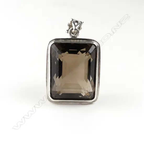 A large topaz and decorative silver pendant
