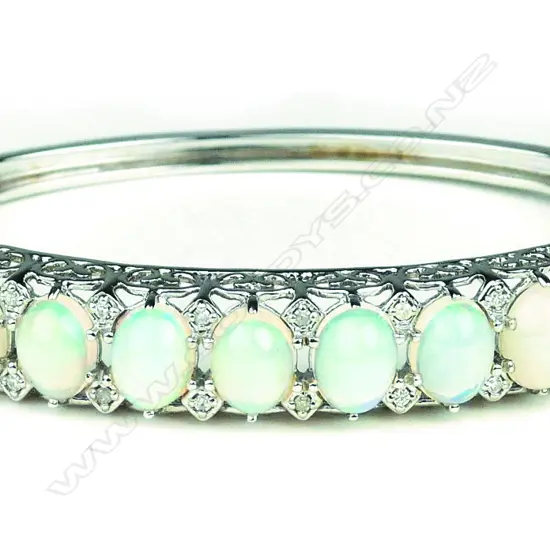 A 14ct white gold opal and diamond hinged bangle