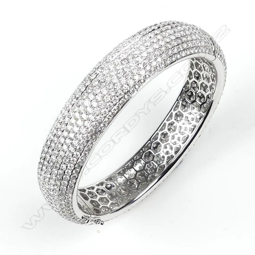 An impressive 18ct. white gold and entirely diamond set half hinged bangle Image 1++
