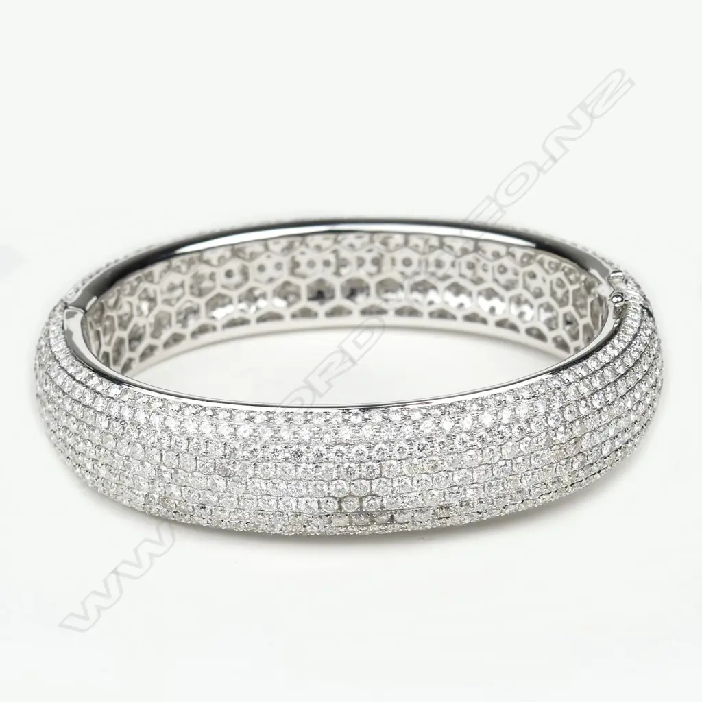 An impressive 18ct. white gold and entirely diamond set half hinged bangle Image 1++
