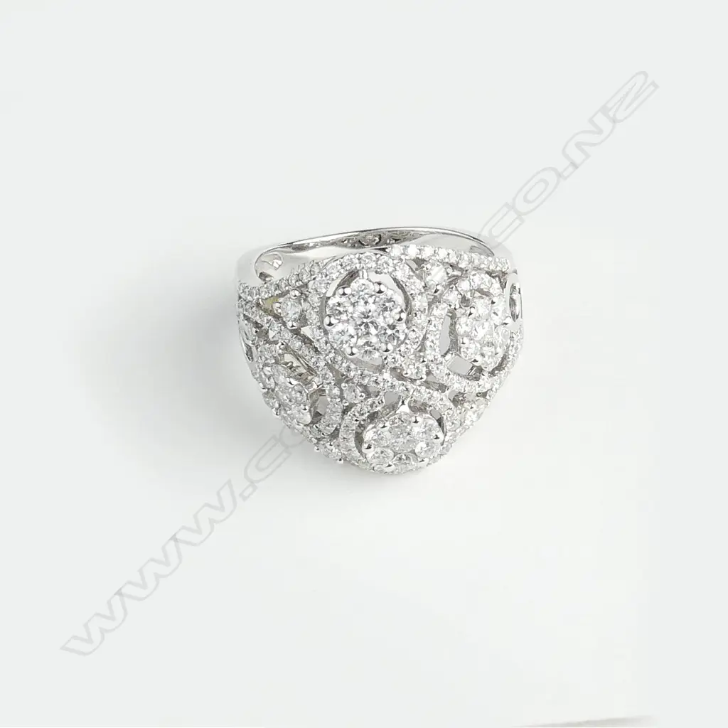 An 18ct. white gold wide multi-diamond cluster set ring Image 1++