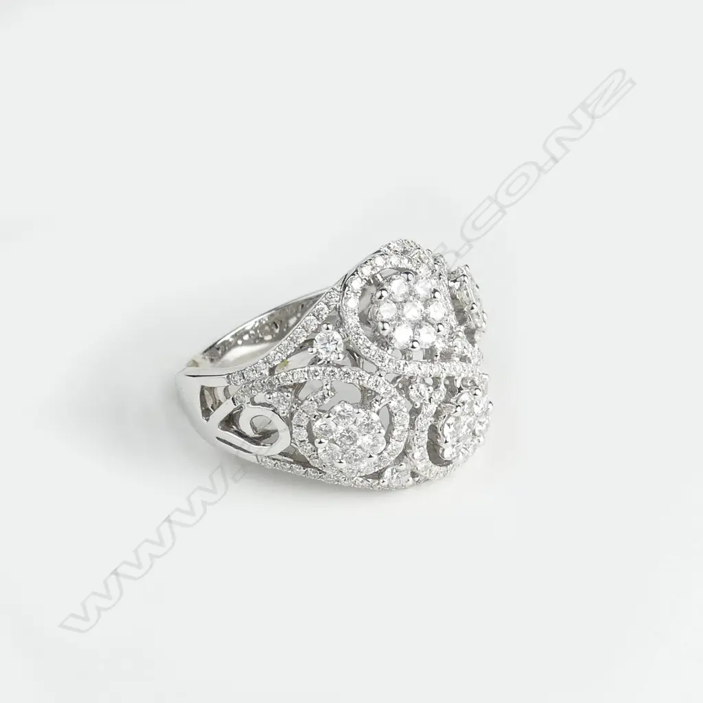 An 18ct. white gold wide multi-diamond cluster set ring Image 1++