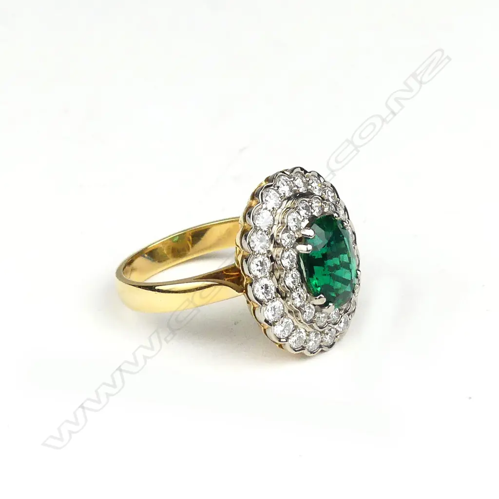 An impressive 18ct. yellow and white gold emerald and multi-diamond cluster ring Image 1++