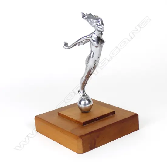 A vintage car mascot of a chromed naked woman