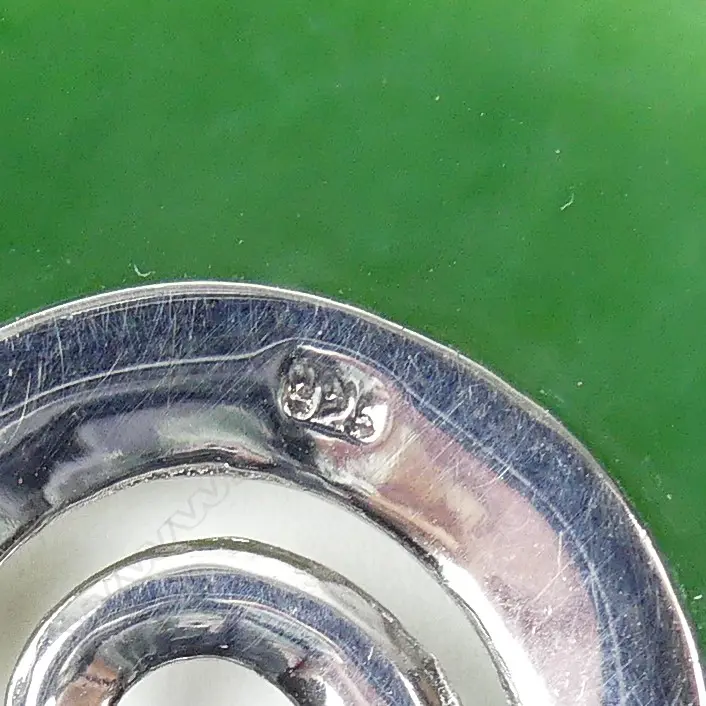 A modern N.Z. greenstone and silver disc form pendant Image 1++