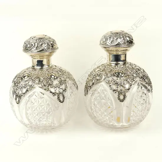 A pair of impressive Edwardian silver topped crystal scent bottles