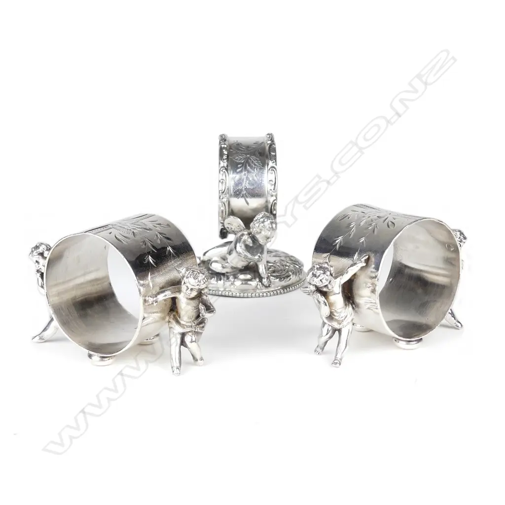 A pair plus one late 19thC American silver plate figured napkin rings Image 1++
