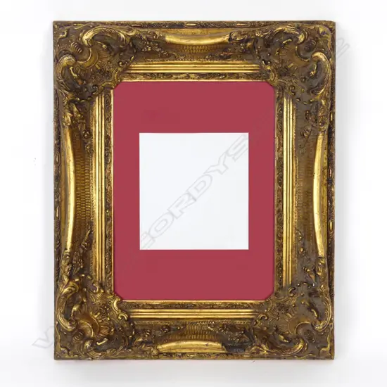 An ornate gilt picture frame with a red card slip