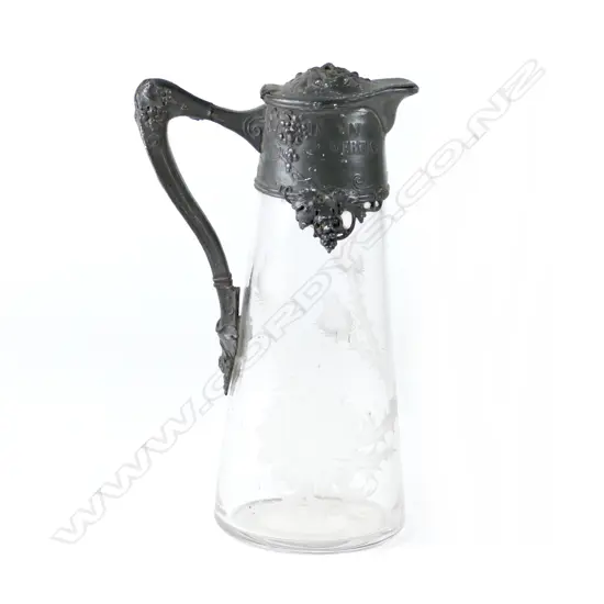 An Art Nouveau pewter and glass claret jug