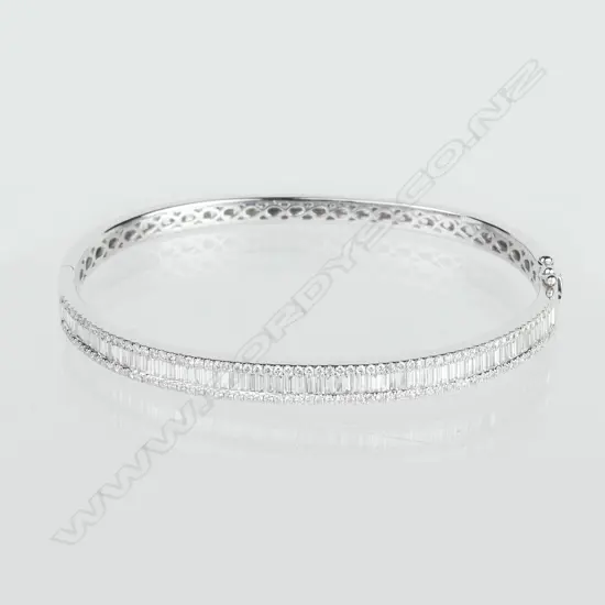 A lady's 18ct. white gold and diamond set half-hinged bangle