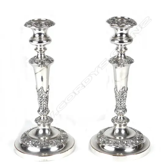 A pair of silver plate on copper column candlesticks