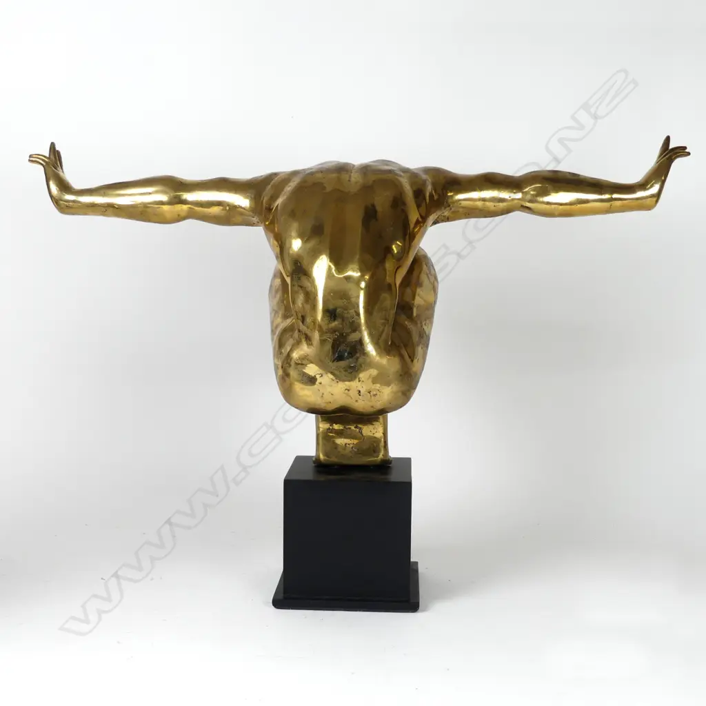 A polished bronze statue of a man in balanced toe stand pose Image 1++