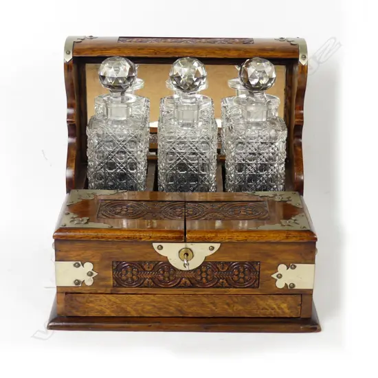 An Edwardian oak three-bottle tantalus