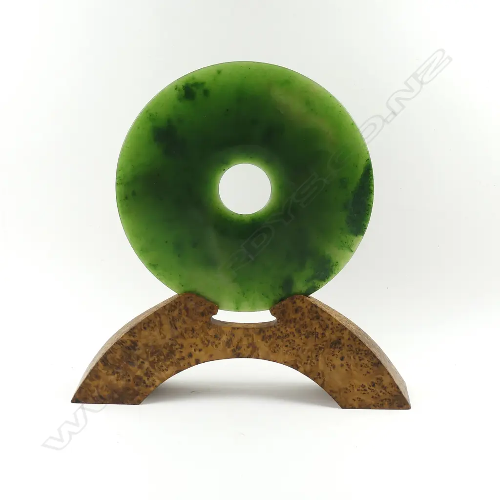 A pounamu bi disc on burr totara stand Image 1++