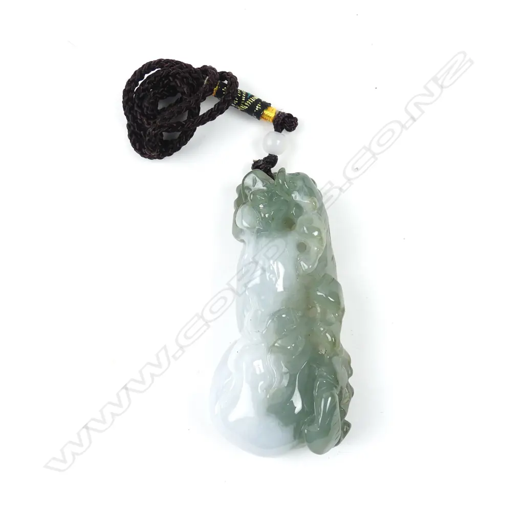 A Chinese semi-translucent green and pale toned carved pendant Image 1++