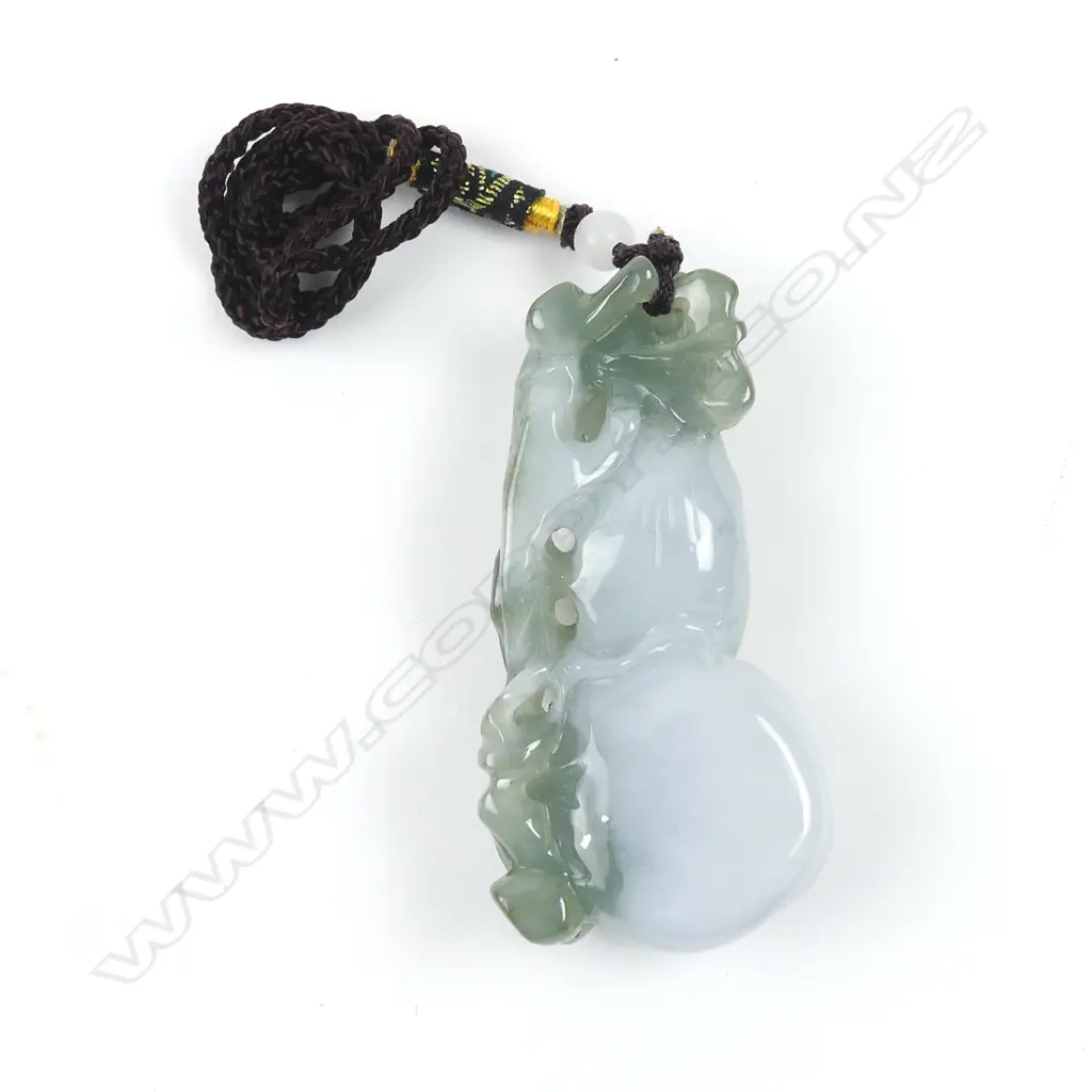 A Chinese semi-translucent green and pale toned carved pendant Image 1++