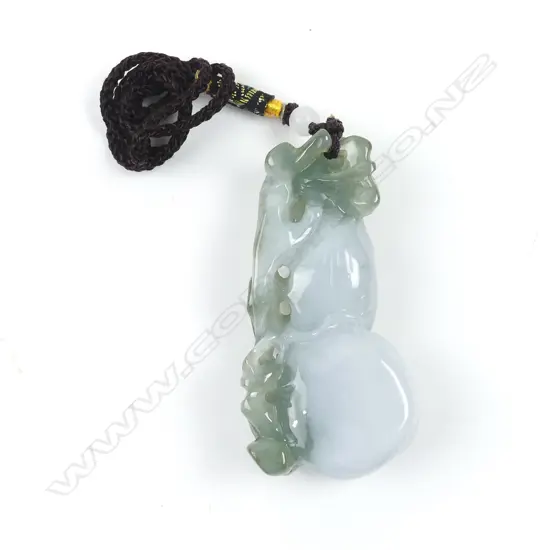A Chinese semi-translucent green and pale toned carved pendant