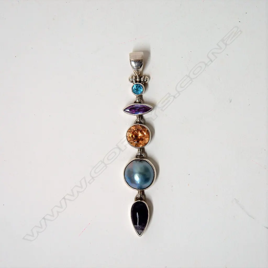 A modern decorative multi-stone and silver long drop pendant Image 1++