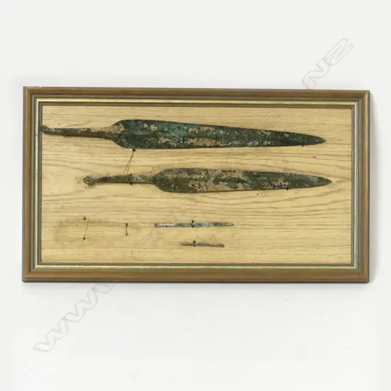 A framed display of two Bronze Age tanged spearheads and two slender bronze pins