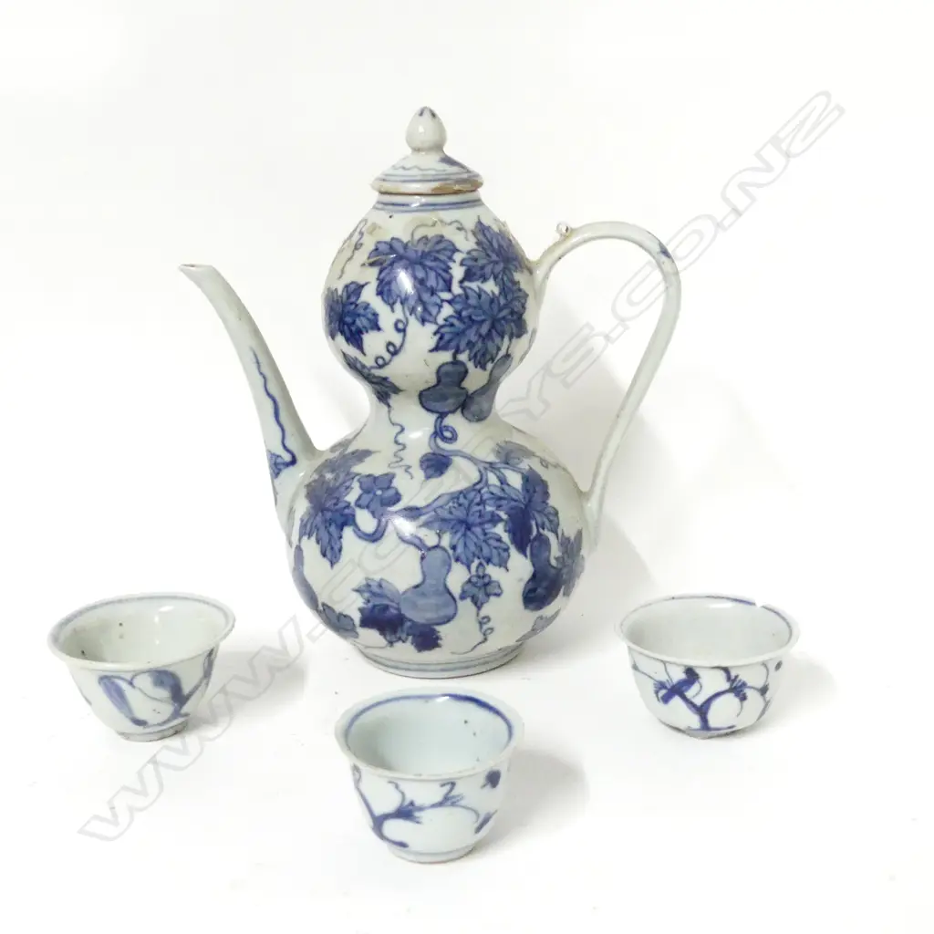 A Chinese blue and white porcelain wine ewer and three small cups Image 1++