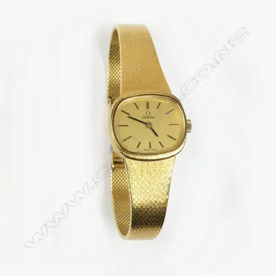 An 18K gold Omega lady's wristwatch with 18K integral mesh bracelet