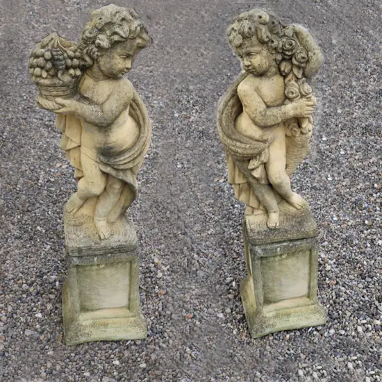 A pair of Church Stone garden statues on plinths