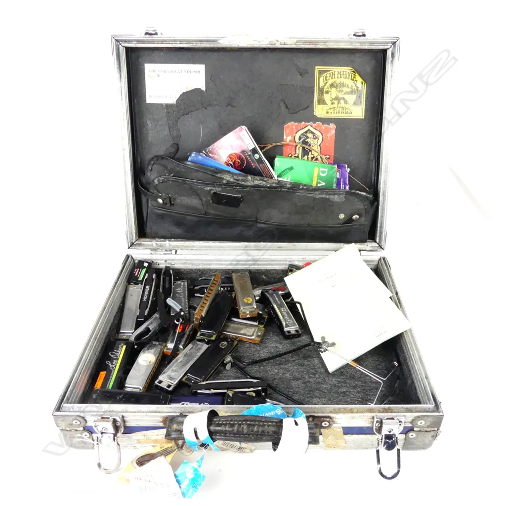 A well-worn road briefcase with approximately 27 assorted harmonicas Image 1++