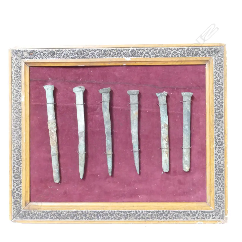 A framed display of six large copper nails Image 1++