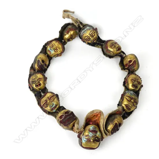 An uncommon Tibetan lama’s collar of thirteen brass masks