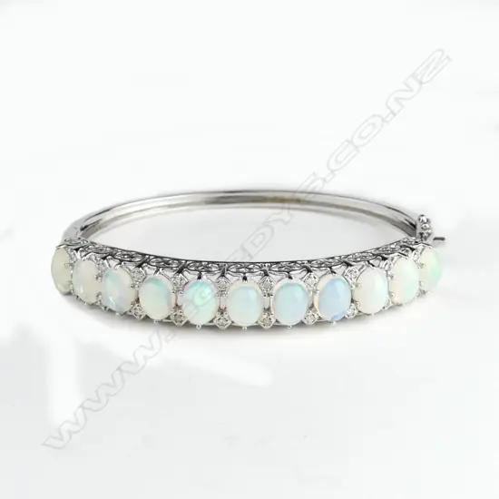 A 14ct white gold opal and diamond bangle