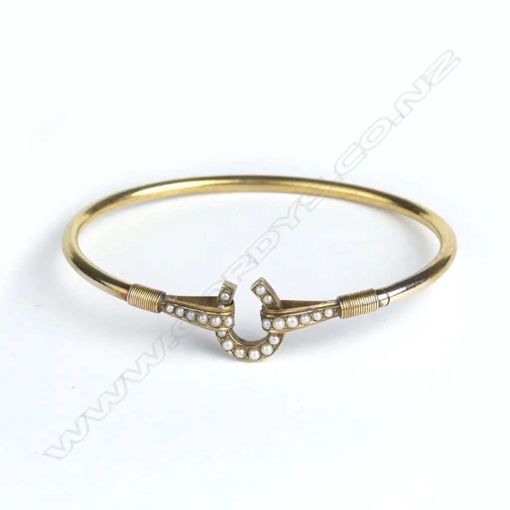 An Edwardian gold horseshoe mounted and seed pearl bangle Image 1++