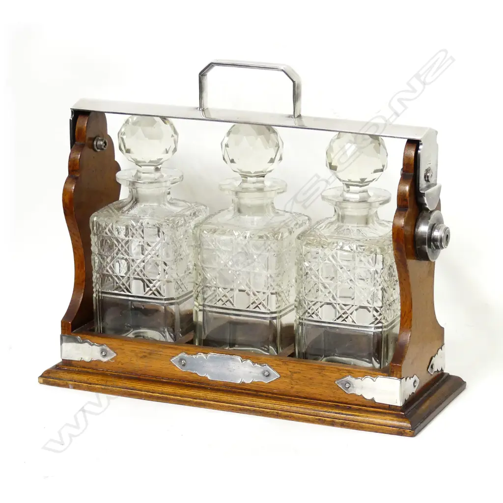 An Edwardian oak and silver plated framed three bottle tantalus Image 1++