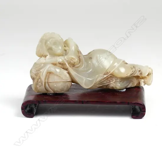 A Chinese carved jade reclining figure of a woman