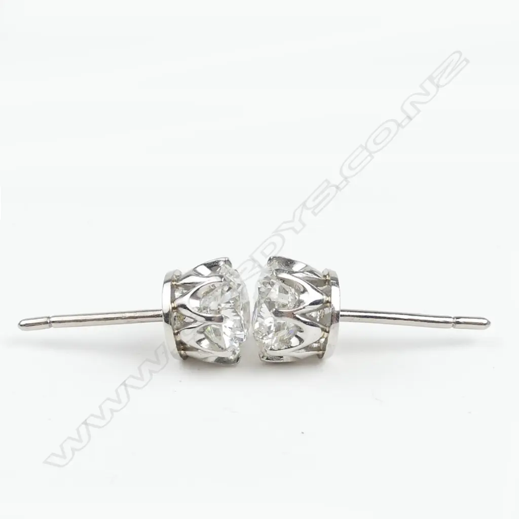 A pair of platinum and 18ct white gold 1ct ea. diamond stud earrings Image 1++