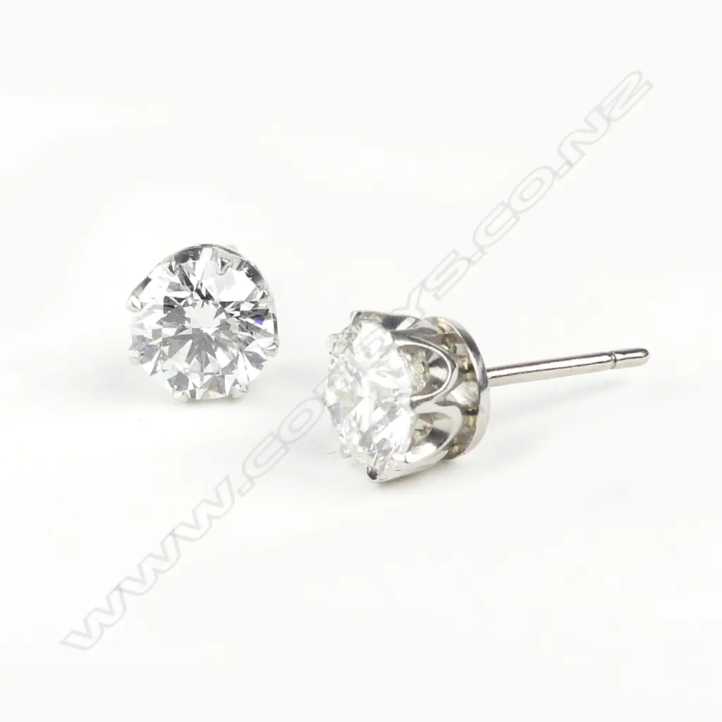 A pair of platinum and 18ct white gold 1ct ea. diamond stud earrings Image 1++