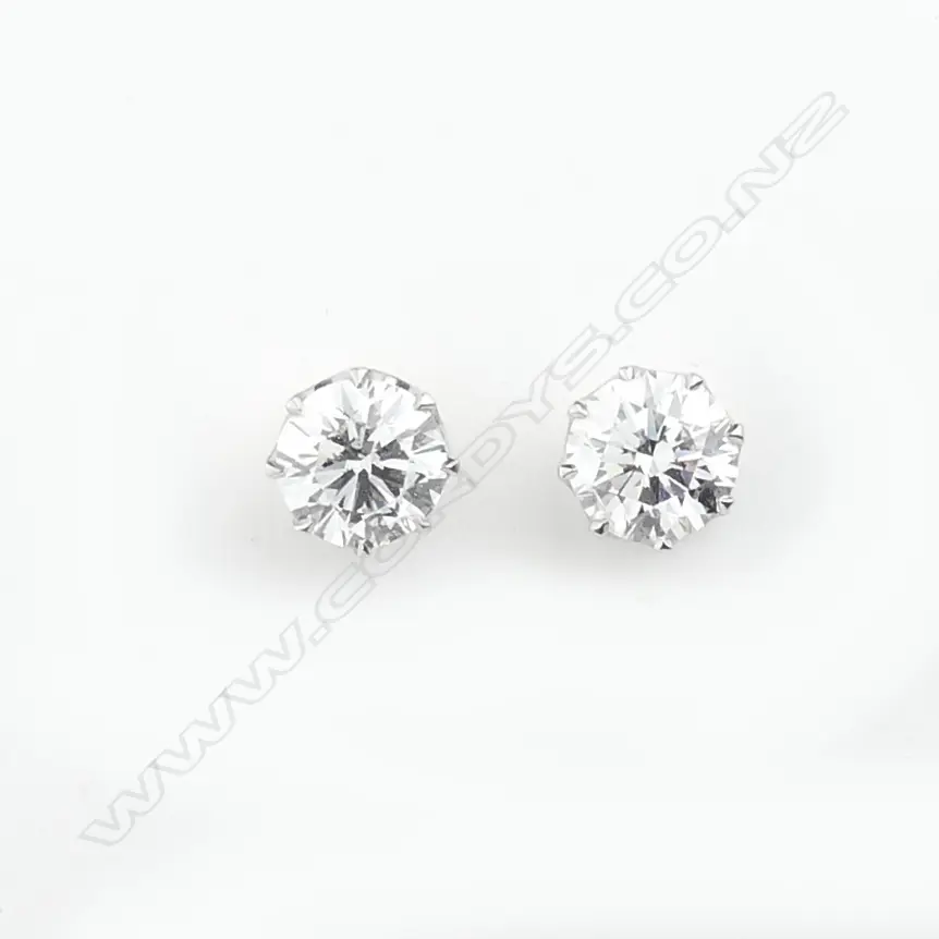 A pair of platinum and 18ct white gold 1ct ea. diamond stud earrings Image 1++