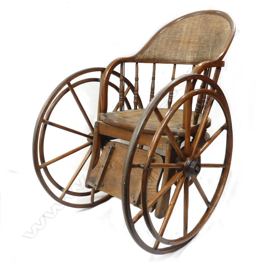 An Edwardian oak and cane wheelchair Image 1++