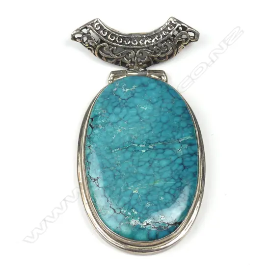 A large turquoise and silver pendant