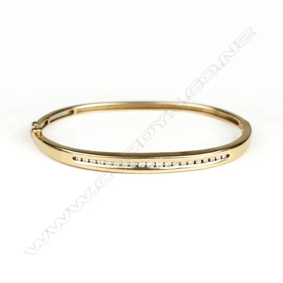 A modern 9ct. yellow gold and 20 diamond hinged snap bangle