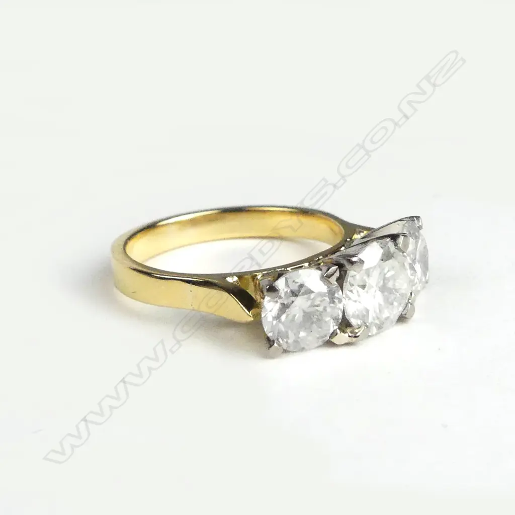 An 18ct yellow and white gold diamond trilogy ring Image 1++