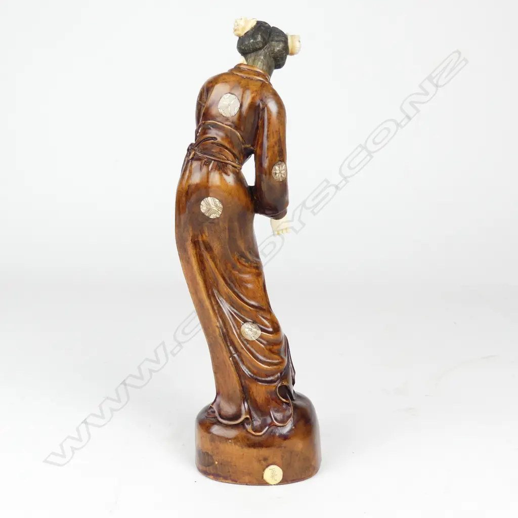 A rosewood and simulated ivory figure of a woman Image 1++