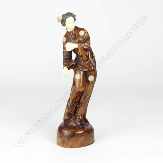 A rosewood and simulated ivory figure of a woman