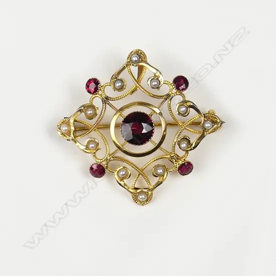An early 20thC 9ct. seed pearl and garnet pendant brooch