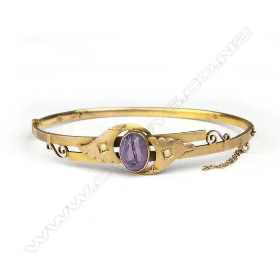 An Edwardian 9ct. gilded yellow gold amethyst hinged bangle
