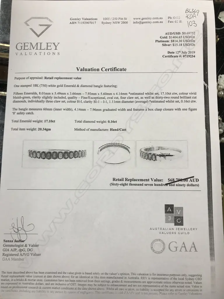 An 18ct white gold emerald and diamond hinged bangle Image 1++